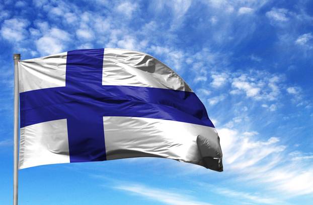 National flag of Finland on a flagpole in front of blue sky