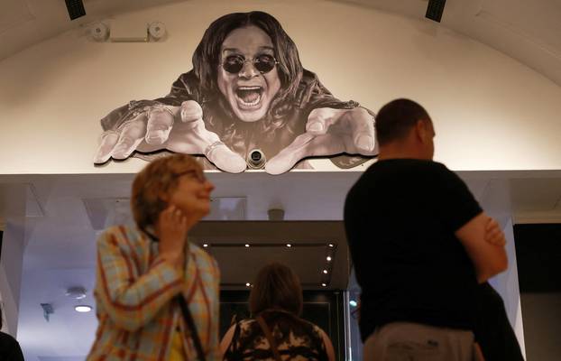 Visitors walk beneath a giant mural as they visit the Ozzy Osbourne exhibition at Birmingham Museum and Art Gallery ahead of Black Sabbath's upcoming concert in Birmingham