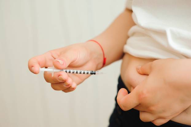 medicine, diabetes, glycemia, health care and people concept - close up of woman hands making injection with insulin pen or syringe