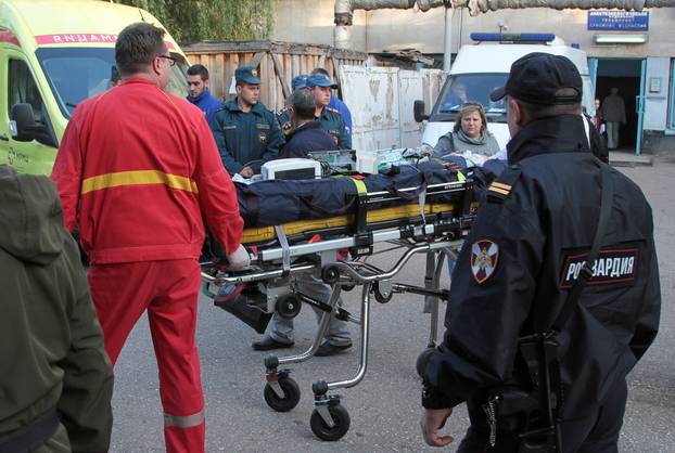 Medics transport injured people following an attack on a local college in Kerch