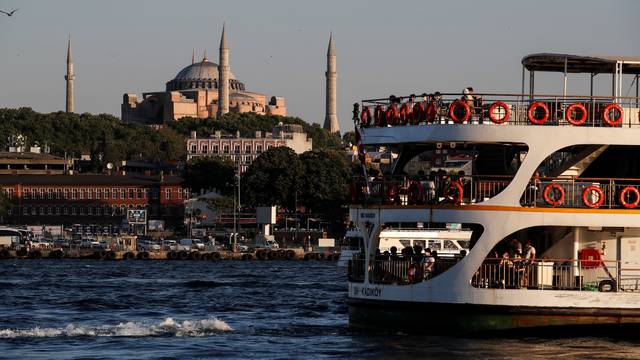 A ferry sails through the waters of Marmara sea as Hagia Sophia or Ayasofya-i Kebir Camii is seen in the background in Istanbul