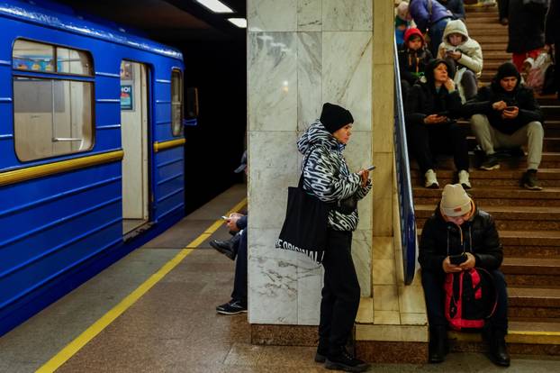 People take shelter inside a metro station during a Russian military attack, in Kyiv