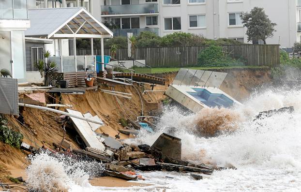 A wave crashes against a swimming pool and properties after they were damaged by severe weather, which brought strong winds and heavy rain to the east coast of Australia, at Collaroy beach in Sydney