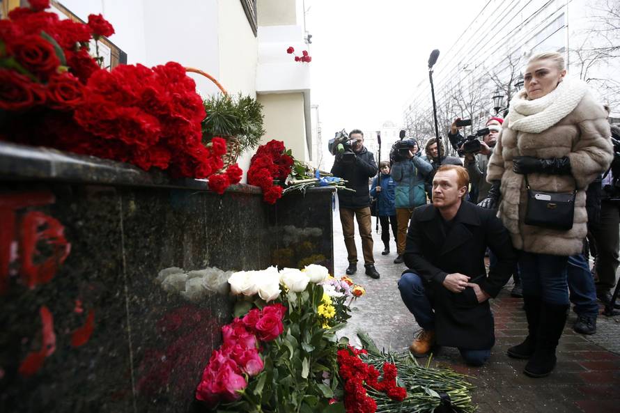 People pay tribute to passengers and crew members of Russian military Tu-154 plane crashed into Black Sea, near makeshift memorial outside headquarters of Alexandrov Ensemble in Moscow 