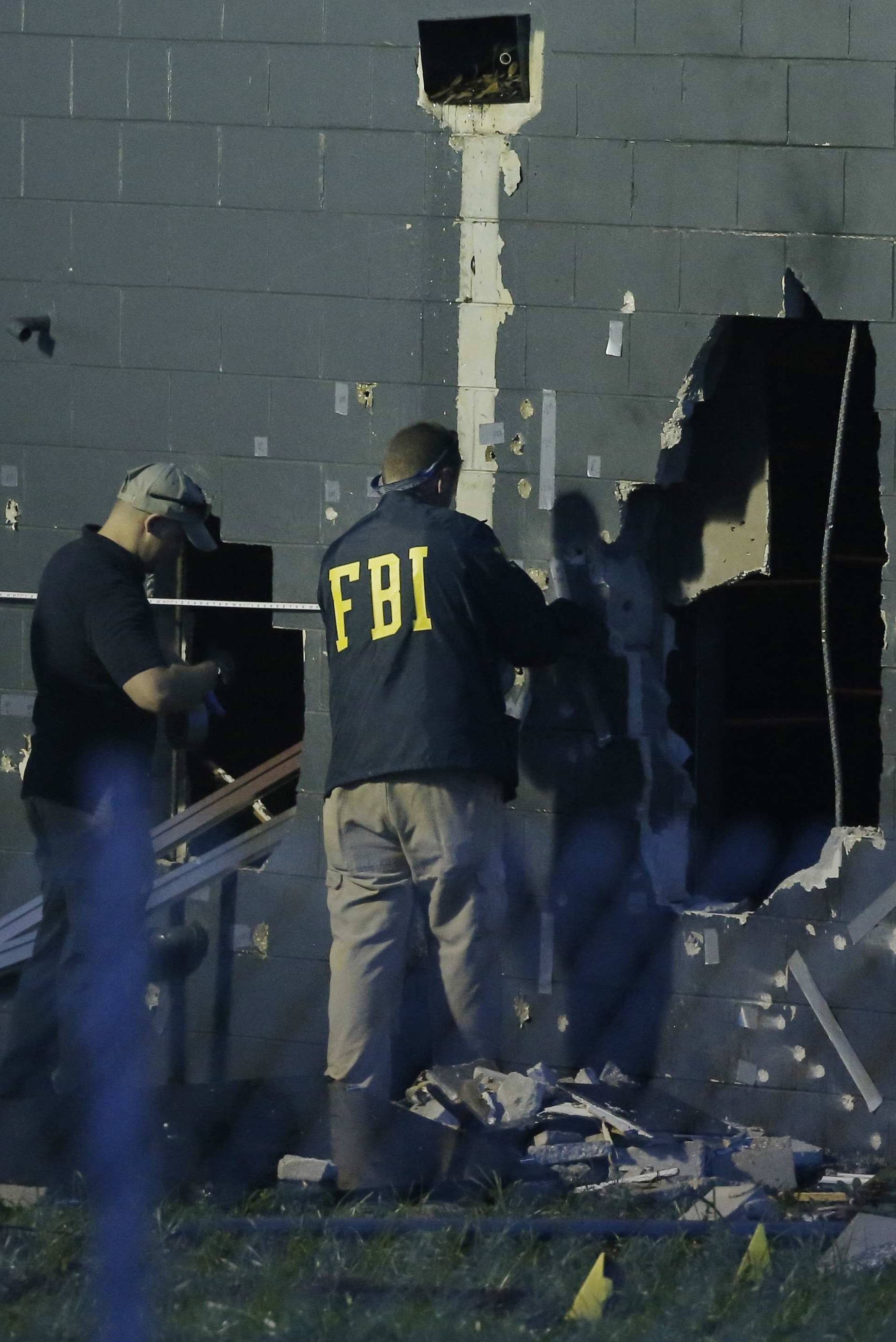 FBI investigators work at the scene of a mass shooting at the Pulse gay night club in Orlando, Florida