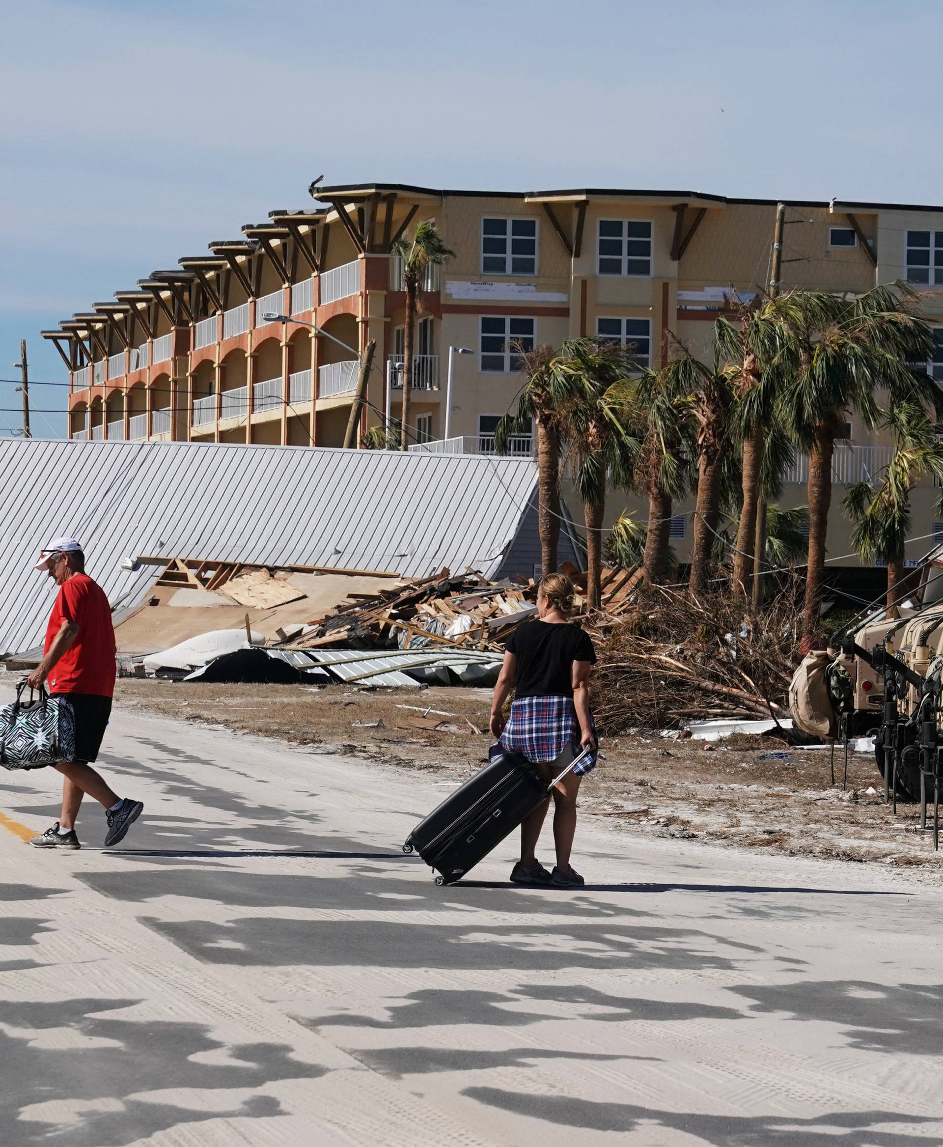 People carry suitcases after Hurricane Michael in Mexico Beach