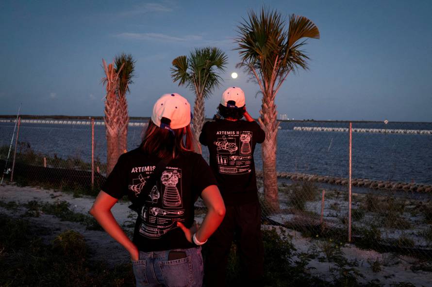 FILE PHOTO: People look at the moon after the launch of the Artemis II mission in Titusville