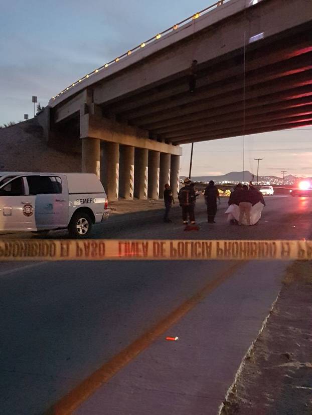 Rescuers attend to bodies that were hanged on the freeway to La Paz