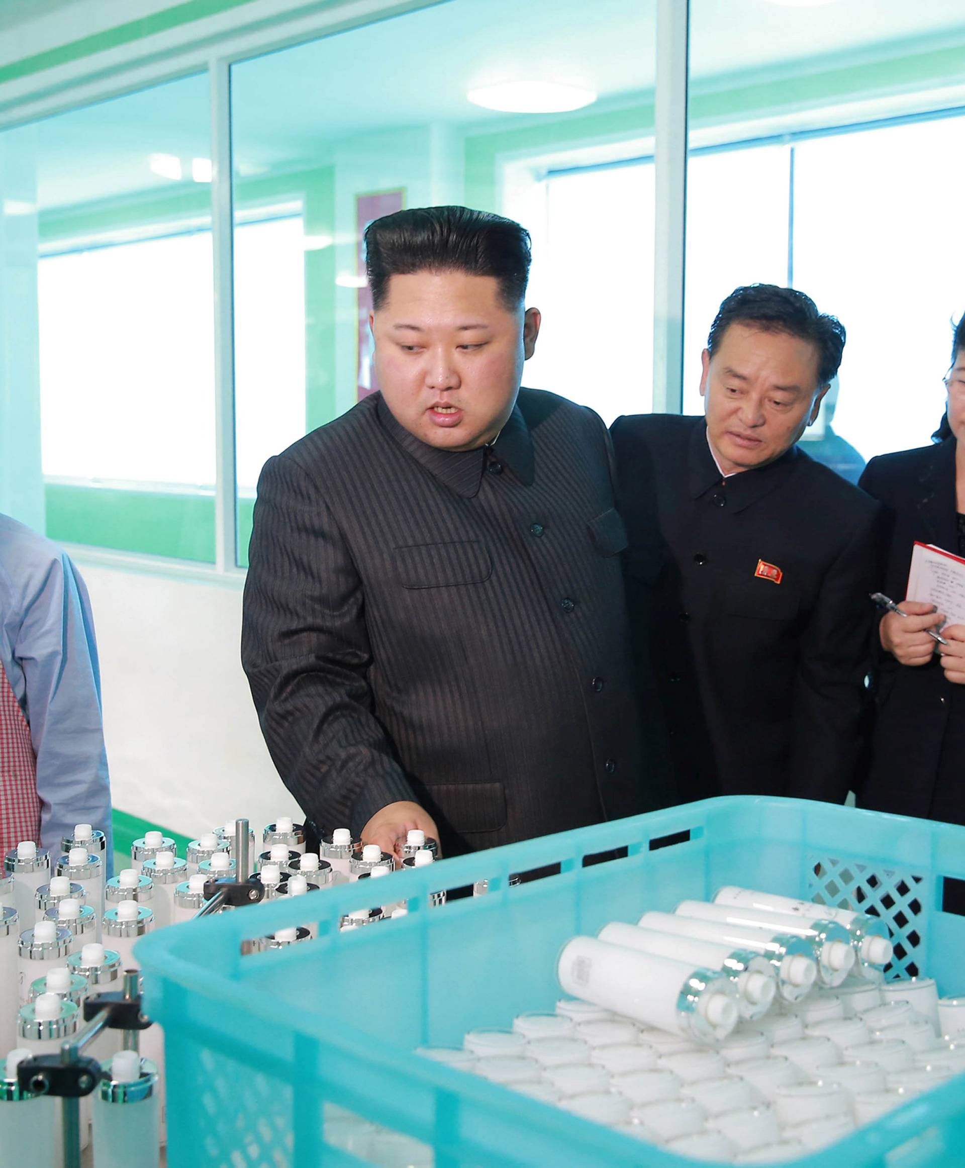 North Korean leader Kim Jong Un and wife Ri Sol Ju visit a cosmetics factory in this undated photo released by North Korea's Korean Central News Agency (KCNA) in Pyongyang