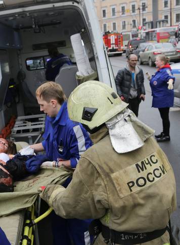 An injured person is helped by emergency services outside Sennaya Ploshchad metro station following explosions in St. Petersburg