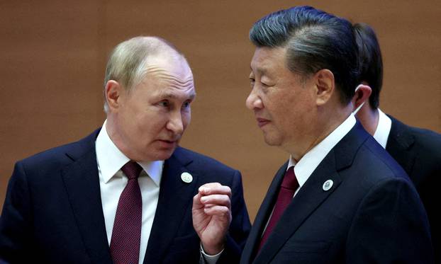 FILE PHOTO: Russian President Vladimir Putin speaks with Chinese President Xi Jinping