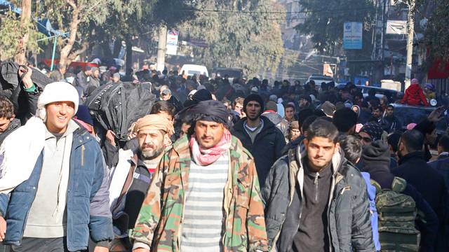 People gather to be evacuated from a rebel-held sector of eastern Aleppo