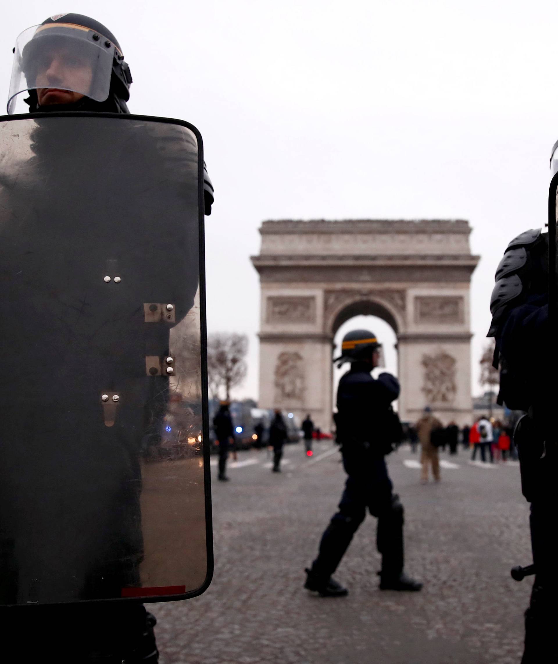 Riot police officers stand guard during a demonstration by the "yellow vests" movement on the Champs Elysees near the Arc de Triomphe in Paris