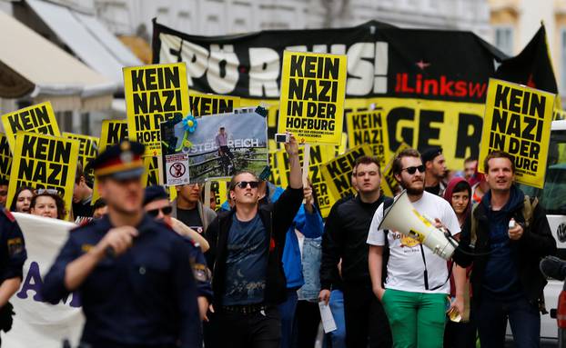 Protestors hold signs during a demonstration against FPOe presidential candidate Hofer in Vienna