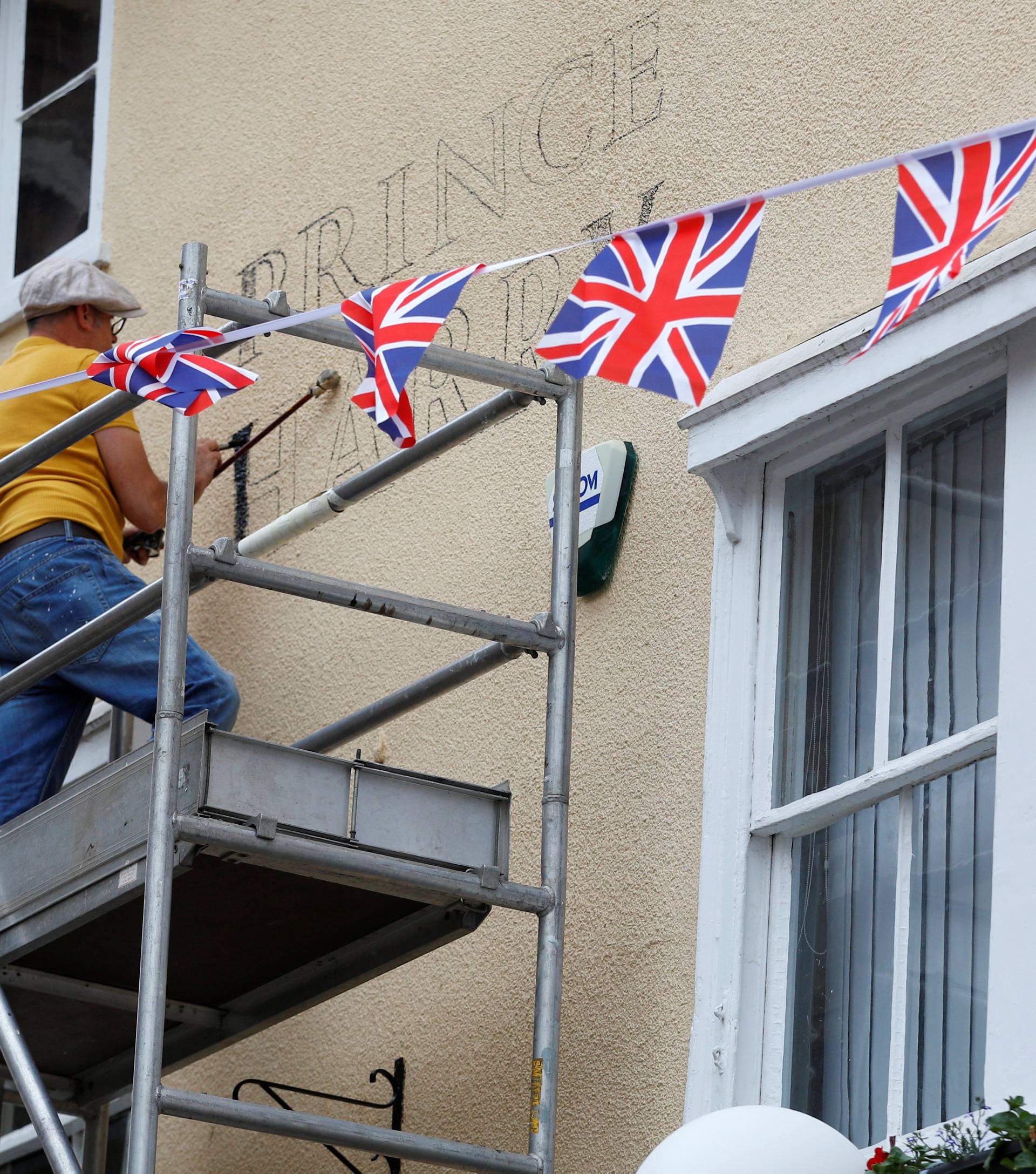 A worker paints the new name on a pub in honour of Prince Harry and Meghan Markle's wedding, in Windsor