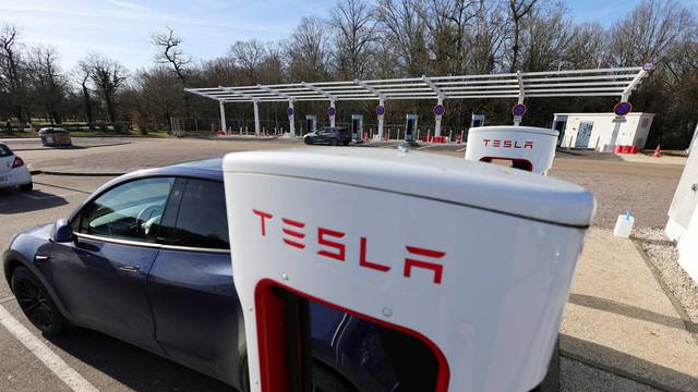 FILE PHOTO: A driver recharges the battery of his Tesla car at a Tesla Super Charging station in Chateauvillain