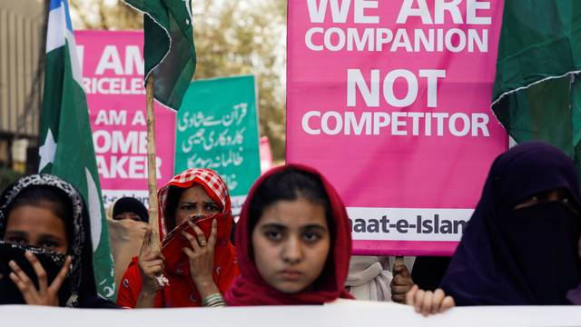 Women supporters of the religious and political party Jamaat-e-Islami (JI) hold signs as they take part in an Aurat March, or Women's March, in Karachi