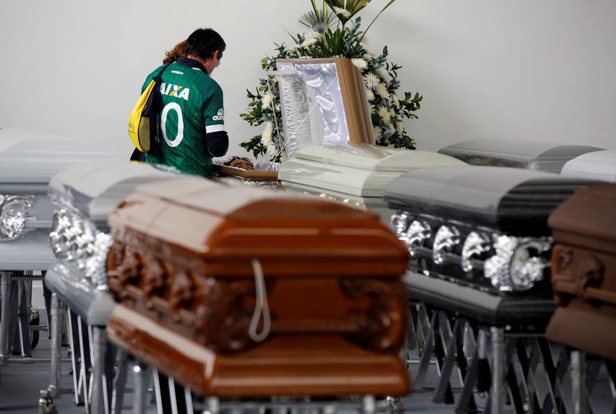 A relative looks into the coffin of Nilson Folle Junior, one of the soccer team's managers and who died along with others in an accident of the plane that crashed into the Colombian jungle with the Brazilian soccer team onboard, in Medellin