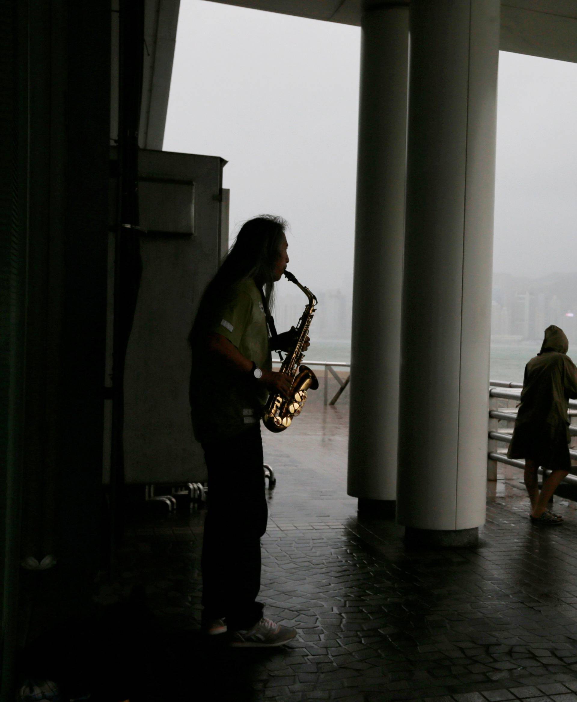 A man plays music as Typhoon Mangkhut approaches Hong Kong