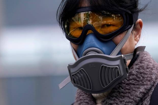 FILE PHOTO: A woman wearing a mask is seen at a subway station in Shanghai