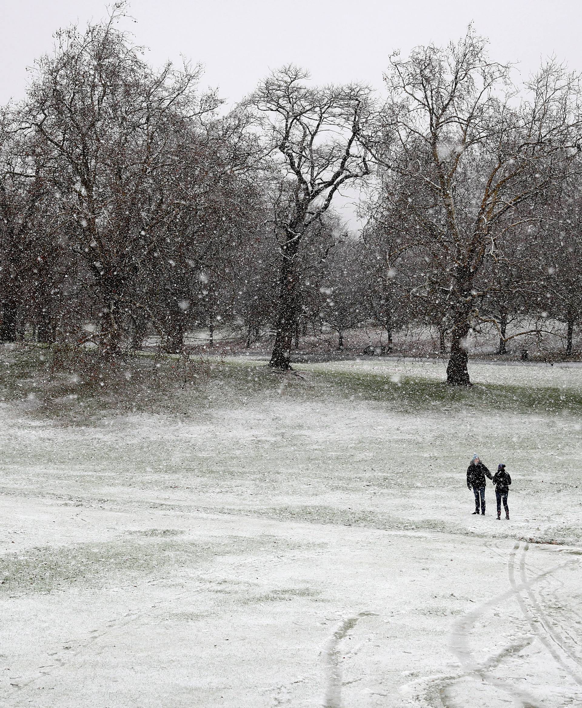 Pedestrians walk through the snow in Greenwich Park, London