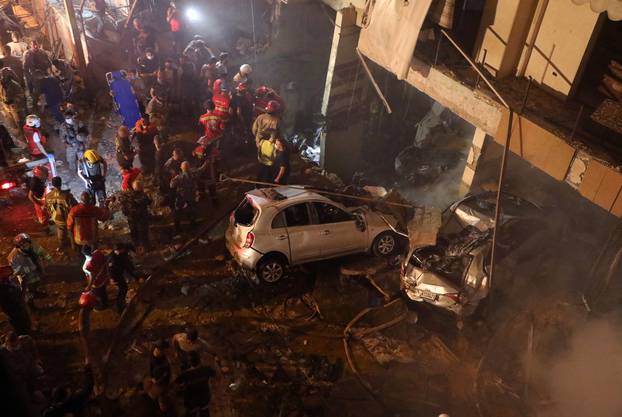 Rescuers work at the site of a fuel tank explosion in the al-Tariq al-Jadida neighborhood of Beirut