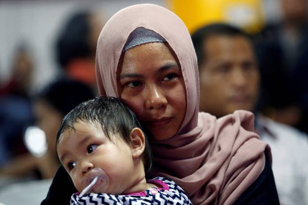 A woman, whose family was on the crashed Lion Air flight JT610, holds her daughter at Bhayangkara R. Said Sukanto hospital in Jakarta