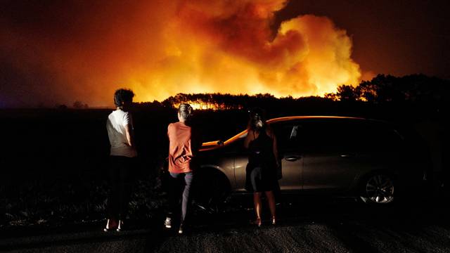 People watch a wildfire in Aljezur