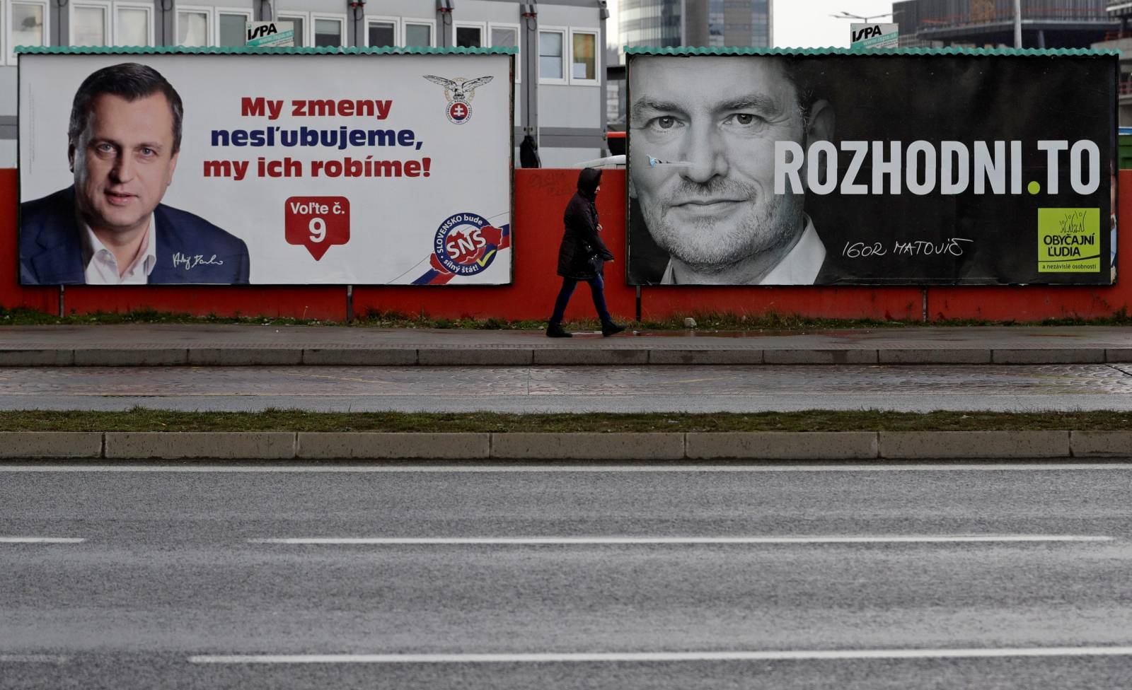 Woman walks past election posters ahead of country's parliamentary election in Bratislava