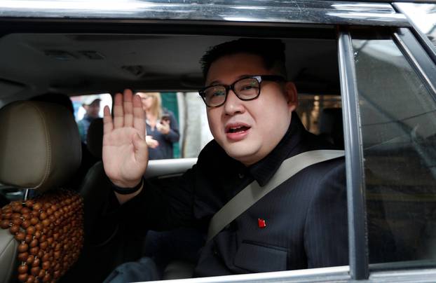 Howard X, an Australian impersonating North Korean leader Kim Jong Un, leaves the La Paix Hotel in a car while escorted by police, in Hanoi