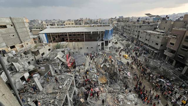 Palestinians inspect the site of Israeli strikes on houses in Jabalia refugee camp, in northern Gaza