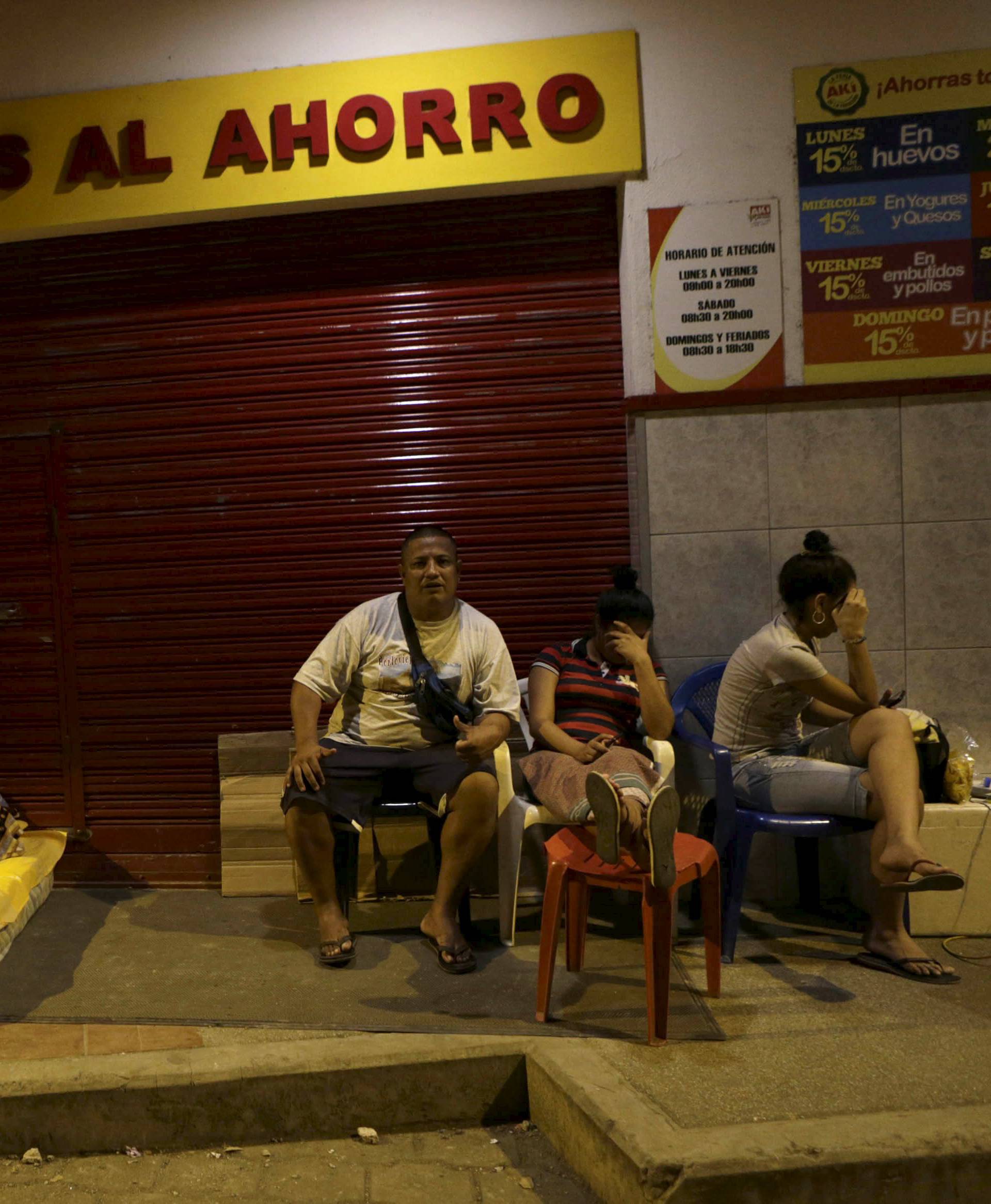 Residents rest on a sidewalk in Portoviejo following the earthquake in Ecuador