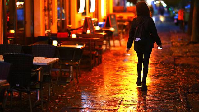 A woman passes empty tables before the late-night curfew due to restrictions against the spread of the coronavirus disease (COVID-19)in Berlin