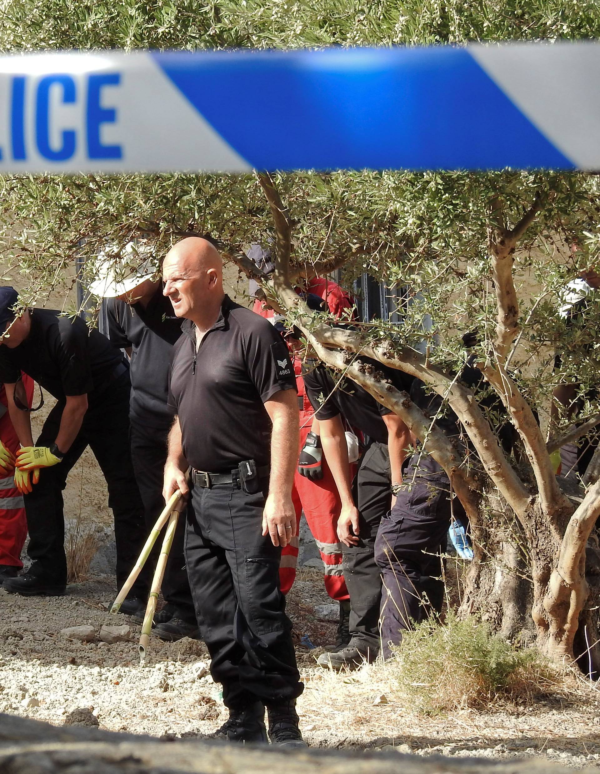 South Yorkshire police officers and members of the Greek rescue service (in red uniforms) investigate the ground before commencing excavating a site for Ben Needham, a 21 month old British toddler who went missing in 1991, on the island of Kos