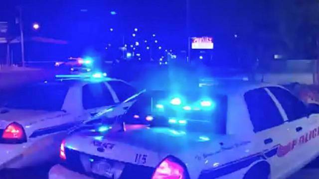 Police vehicles are seen near the scene in the aftermath of a drive-by shooting at a liquor store in Shreveport, Louisiana