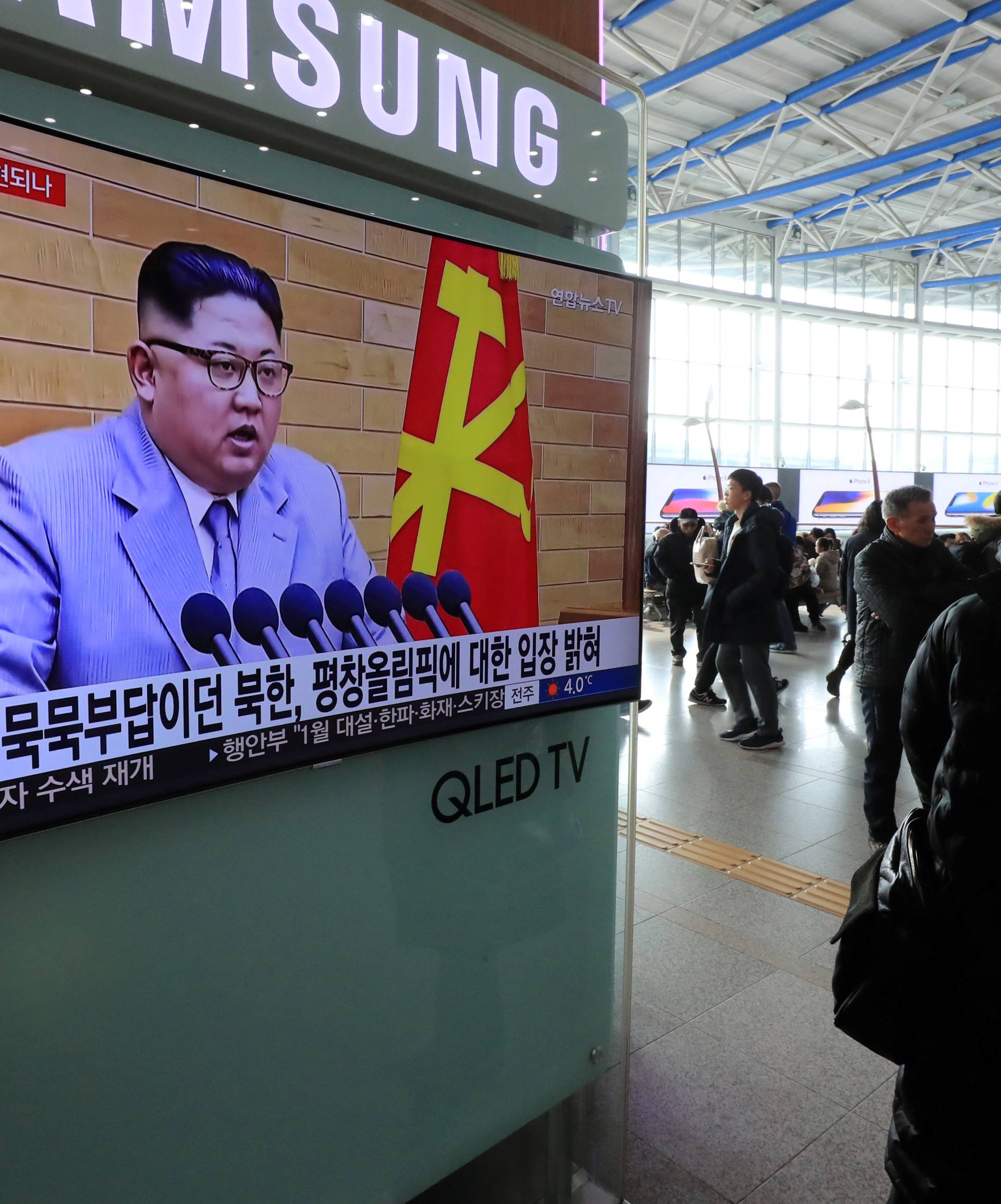 People watch a TV broadcasting a news report on North Korea's leader Kim Jong Un speaking during a New Year's Day speech, in Seoul