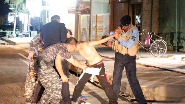 Iraqi security forces remove a suicide vest from a boy in Kirkuk