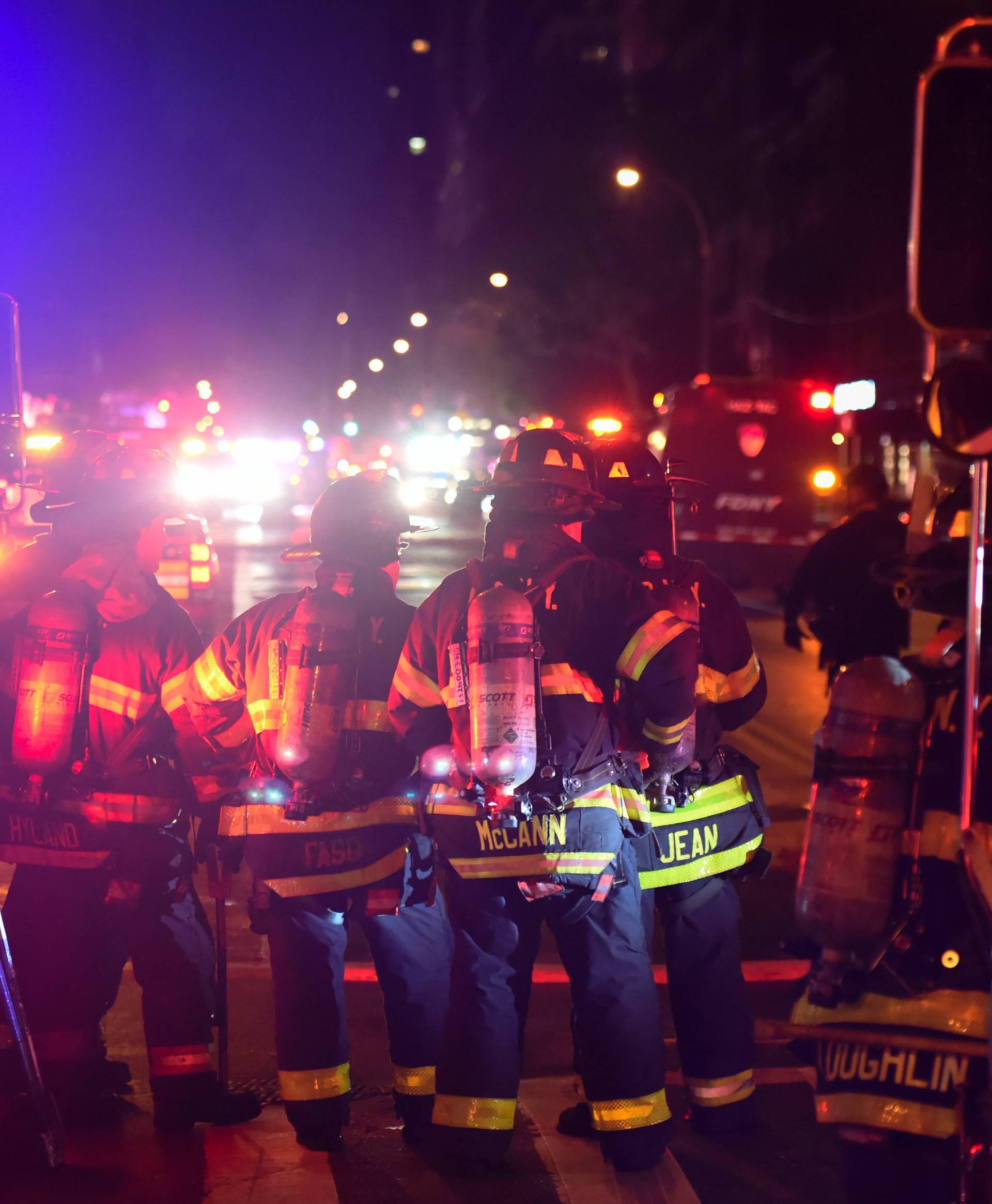 New York City firefighters stand near the site of an explosion in the Chelsea neighborhood of Manhattan, New York