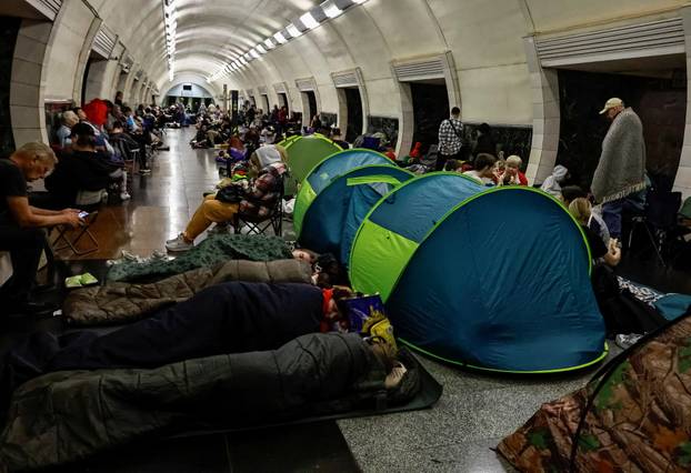 People take shelter inside a metro station during a Russian drone and missile strike in Kyiv