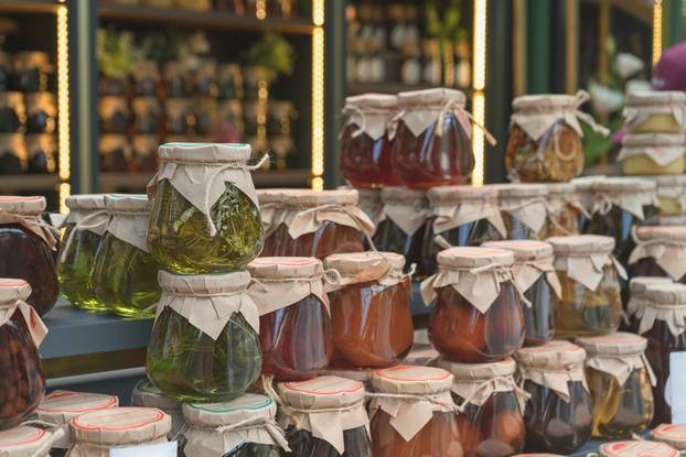 Market,Stall,Displaying,A,Bunch,Of,Stacked,Colorful,Glass,Jars