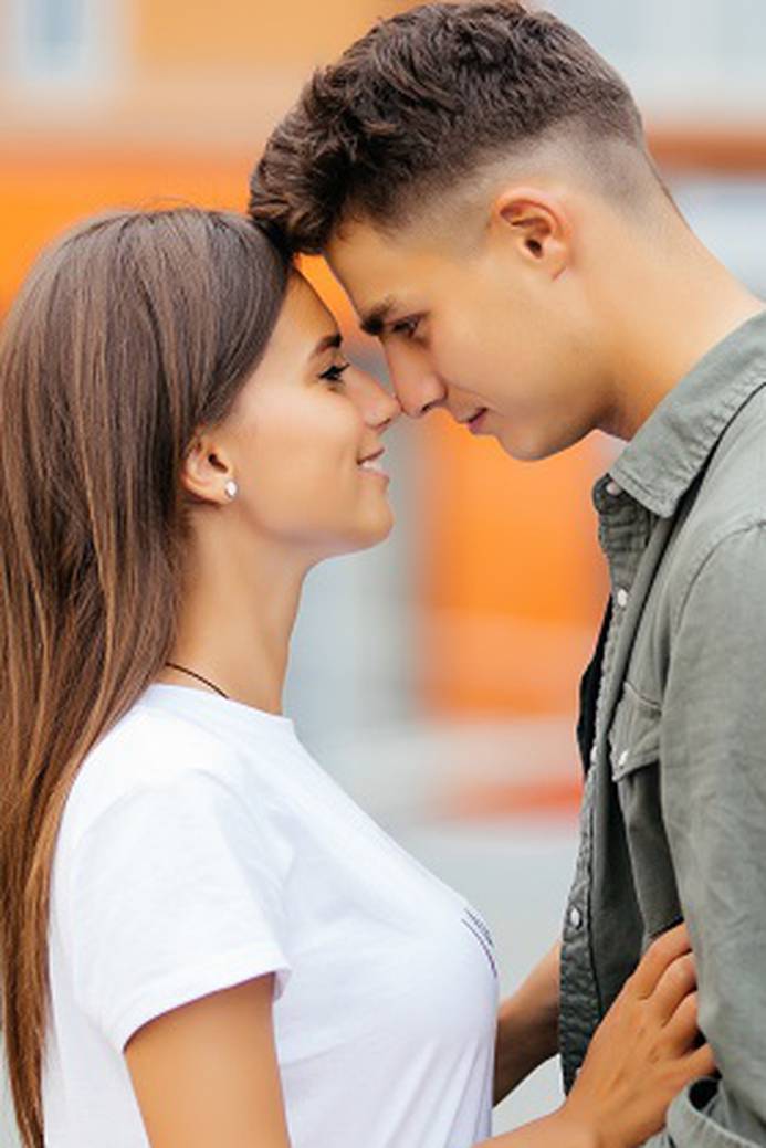 Happy teen couple embracing at street.