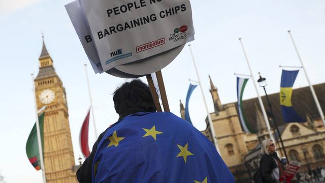 FILE PHOTO - A demonstrator holds a placard during a protest in favour of amendments to the Brexit Bill outside the Houses of Parliament, in London