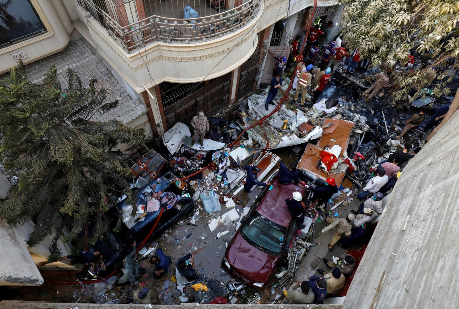 Rescue workers gather at the site of a passenger plane crash in a residential area near an airport in Karachi