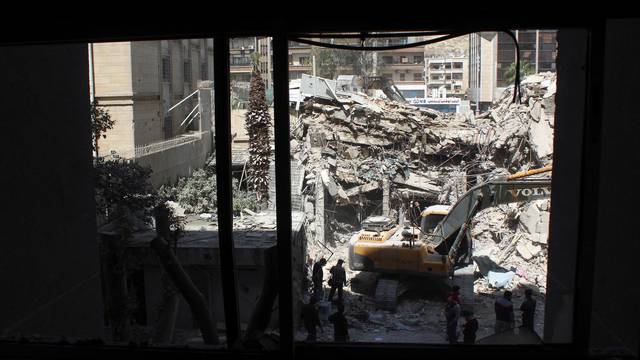 An excavator clears rubble after a suspected Israeli strike on Iran's consulate, in Damascus