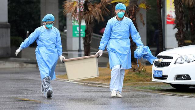 Medical staff carry a box as they walk at the Jinyintan hospital, where the patients with pneumonia caused by the new strain of coronavirus are being treated, in Wuhan