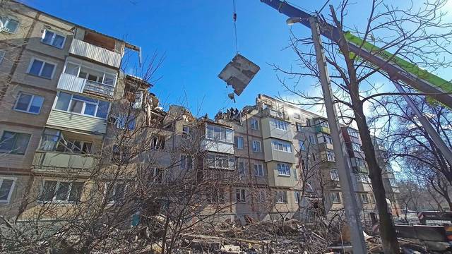Rescuers remove debris from a residential building damaged by an airstrike in Kharkiv