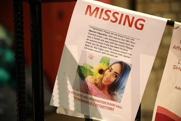 A missing persons leaflet is displayed near a tower block severely damaged by a serious fire, in north Kensington, West London