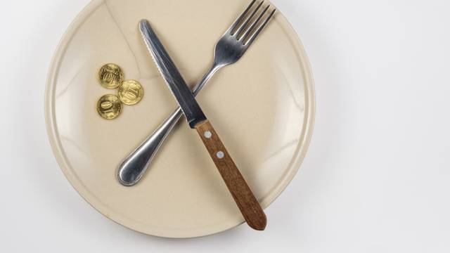 An empty cracked plate with knife and fork, it is based on three ten-coin