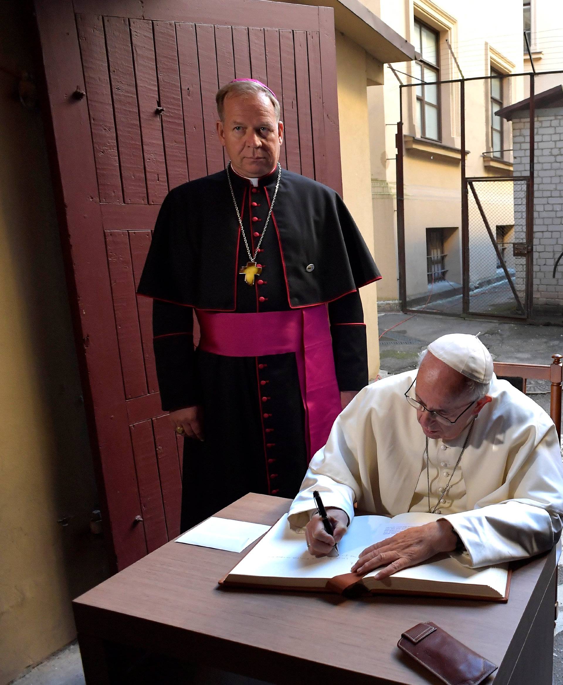 Pope Francis writes a message in the visitor's book at the Museum of Occupations and Freedom Fights, in Vilnius
