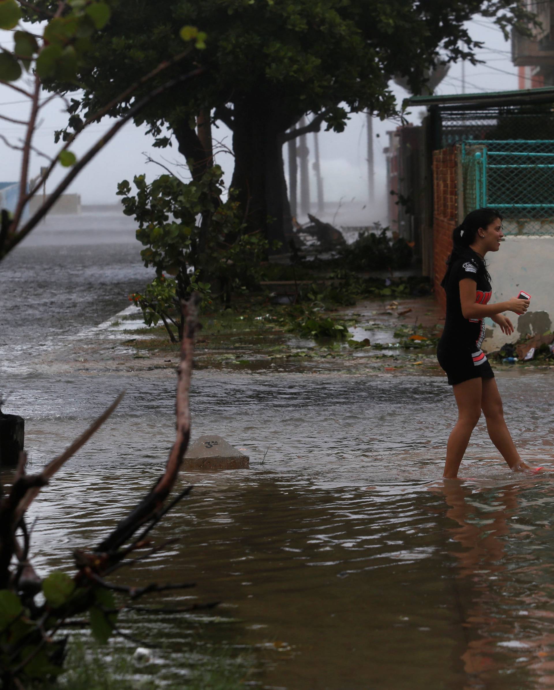 A woman wades through a flooded street as Hurricane Irma turns toward the Florida Keys on Saturday, in Havana